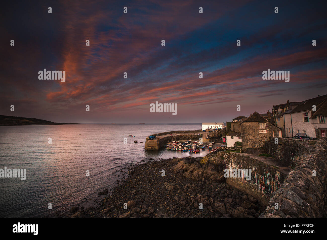 Le port pittoresque et la baie de la Cornish village de pêcheurs de Coverack dans Cornwall, uk lors d'un coucher de soleil spectaculaire. Banque D'Images