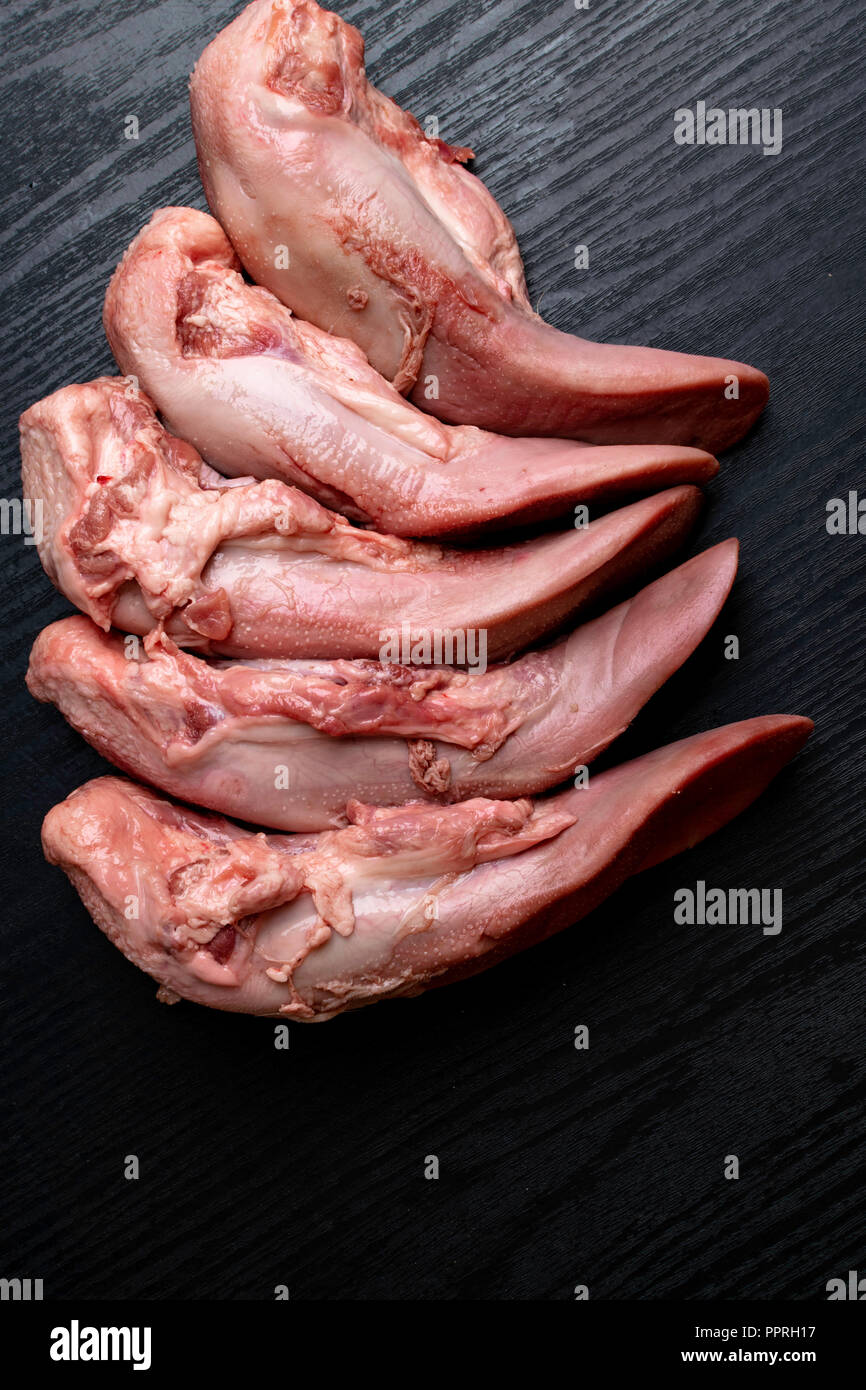 Langues De Boeuf Ou De Porc Cru Sur Un Parquet En Bois Noir