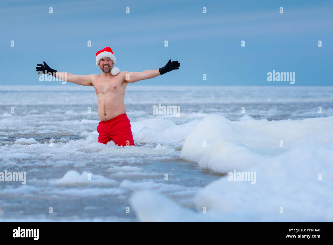 Dans un baigneur hiver Santa's hat reste dans une mer gelée Banque D'Images