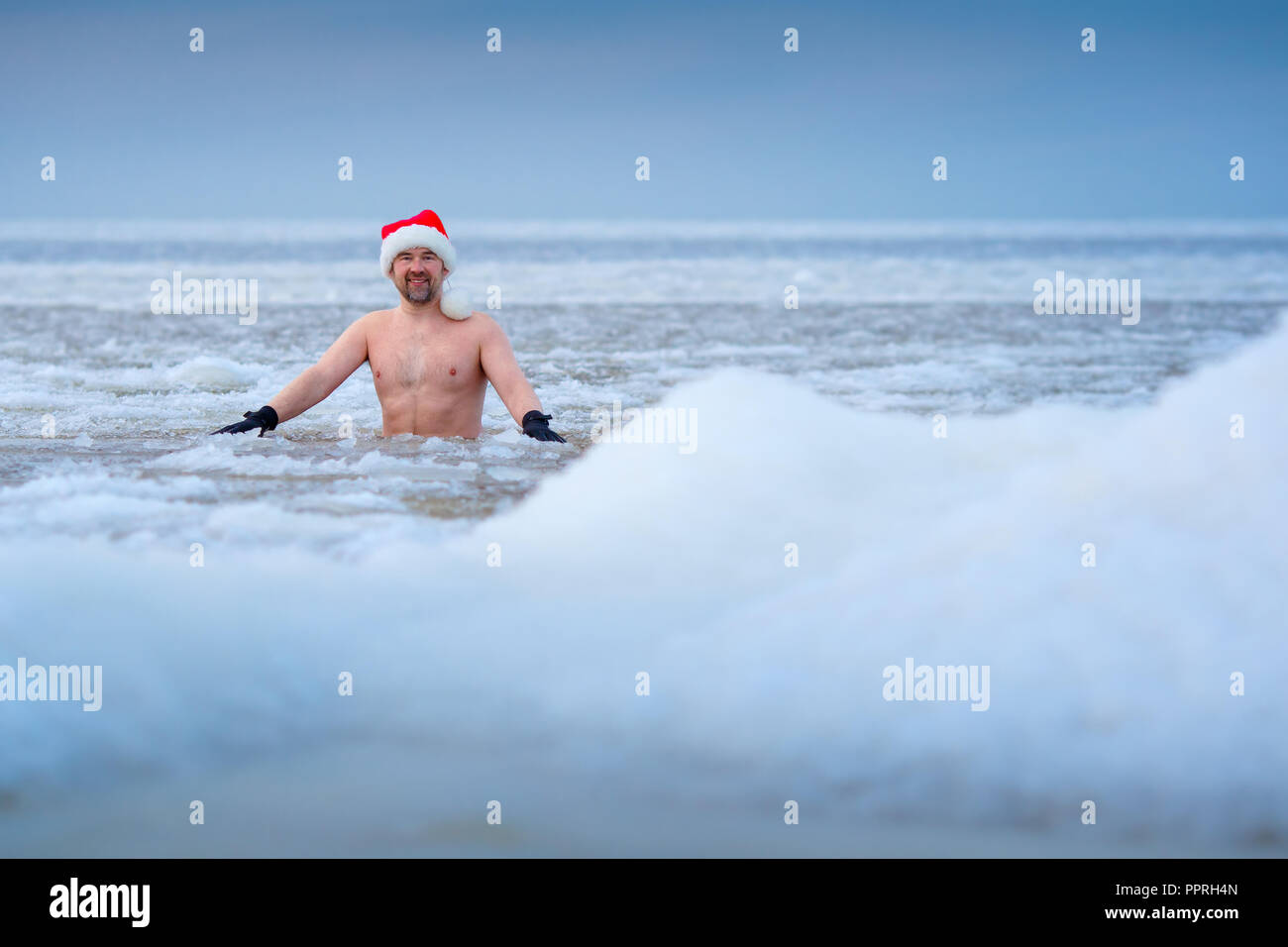 Dans un baigneur hiver Santa's hat reste dans une mer gelée Banque D'Images