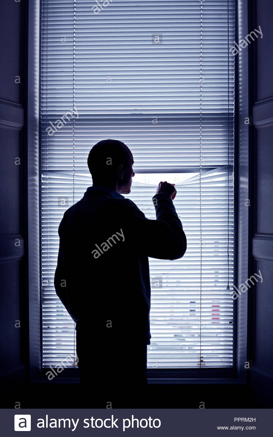 L'homme à la fenêtre par blind Banque D'Images