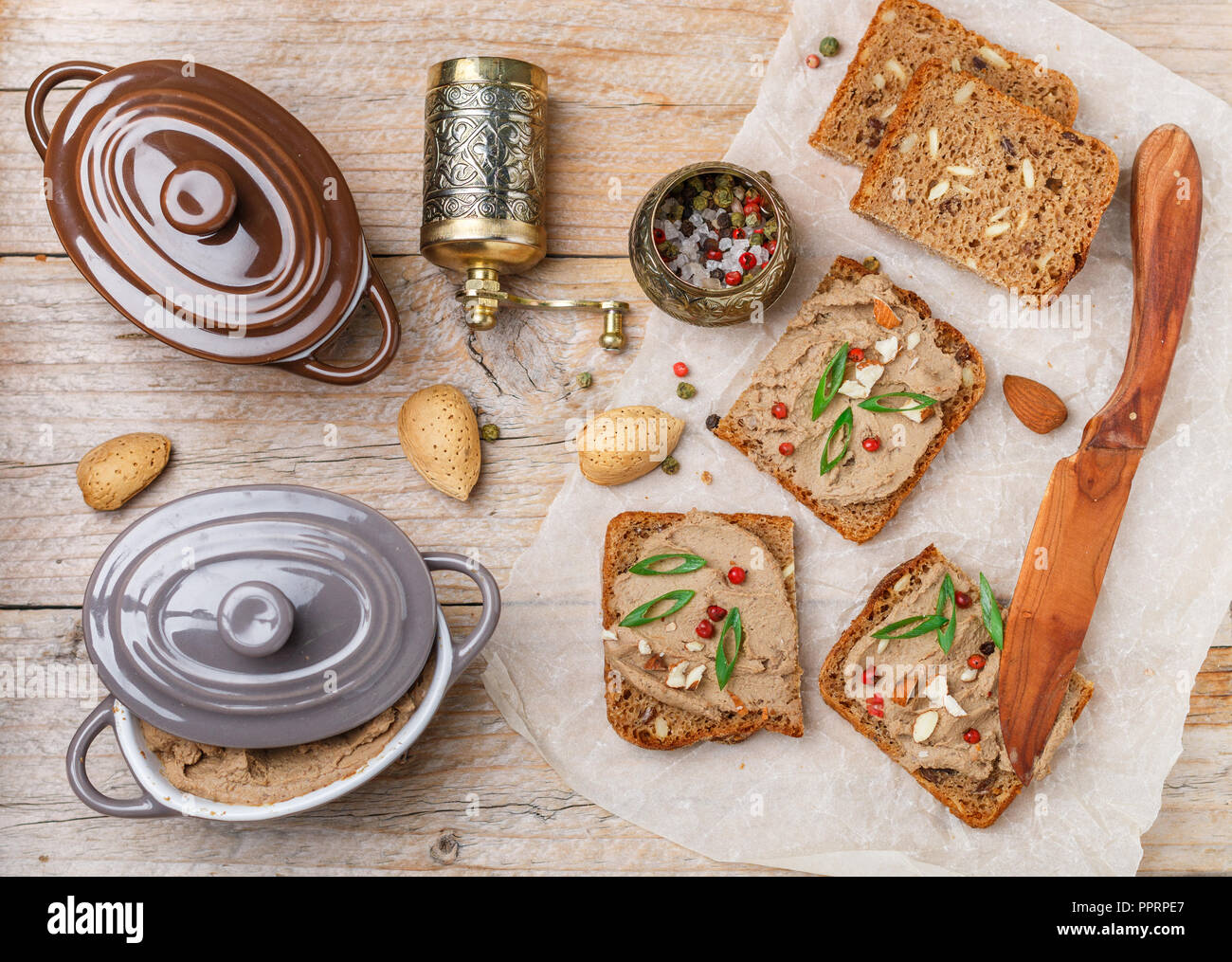 Des poulets (canard, oie, lapin, Turquie) pâté de foie avec les amandes, le poivre rose et les oignons verts sur pain de grains entiers avec des graines. Tradition Banque D'Images