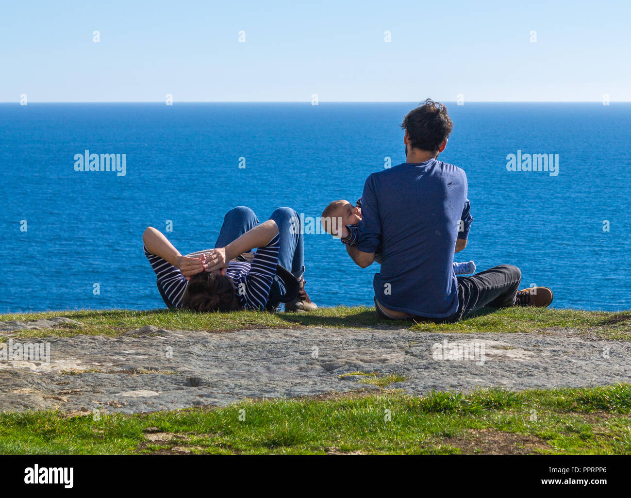 Couple et l'enfant bénéficiant d'été sur des vacances à la mer sur la falaise Banque D'Images