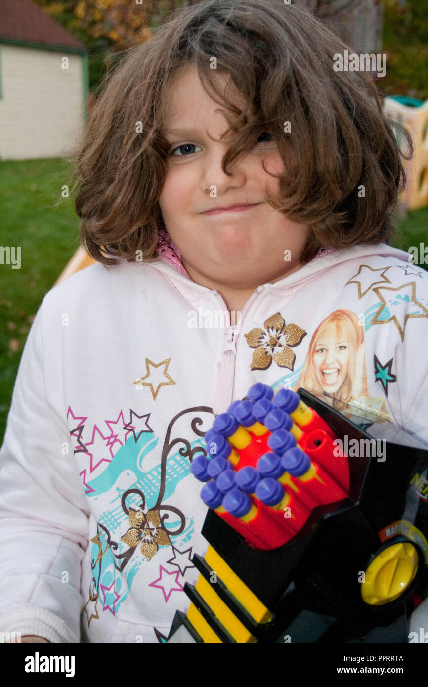 Fille perplexe l'âge de 10 ans, titulaire d'un Nerf automatique Rapid Fire 20 toy machine gun. St Paul Minnesota MN USA Banque D'Images