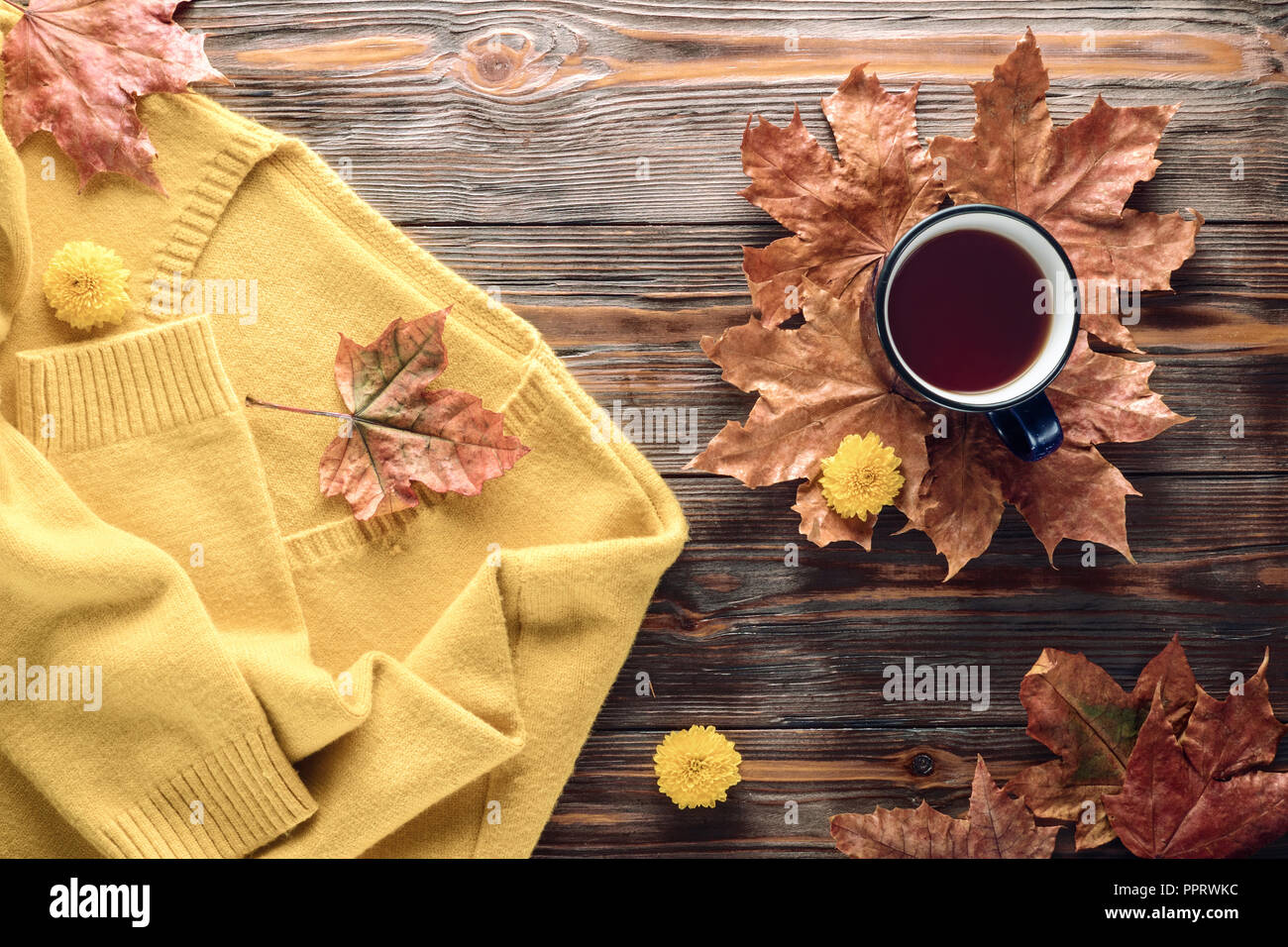 La mode d'automne, concept de saison chaude chandail jaune confortable cardigan tasse de thé noir chaud automne feuilles d'érable café tombé sur table en bois Télévision Banque D'Images