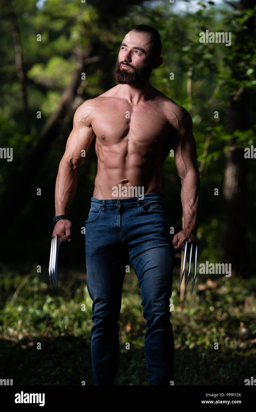 Wolverine avec pinces soyons forts à l'extérieur et Flexing Muscles - Super-héros athlétique Posing Banque D'Images
