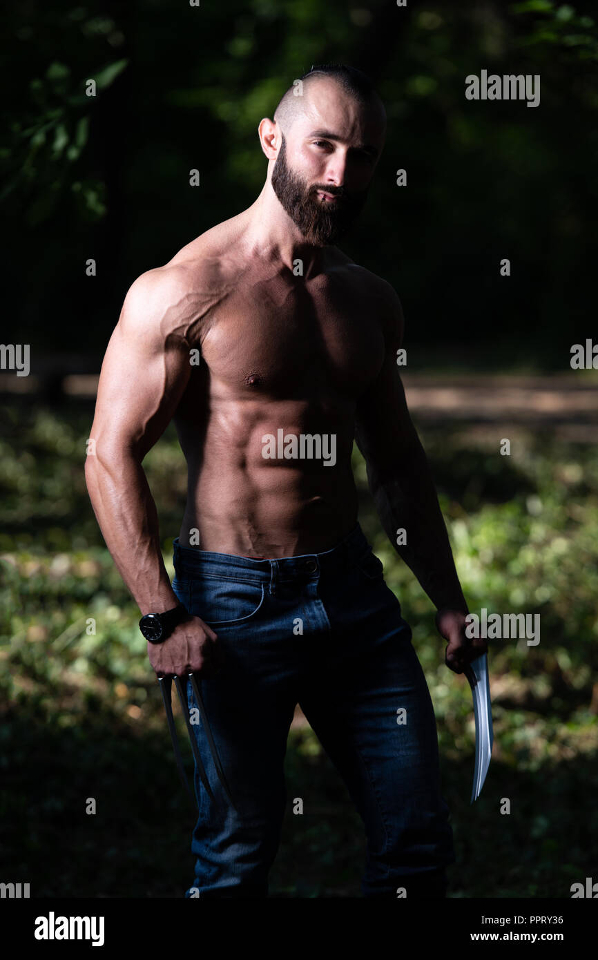 Wolverine avec pinces soyons forts à l'extérieur et Flexing Muscles - Super-héros athlétique Posing Banque D'Images