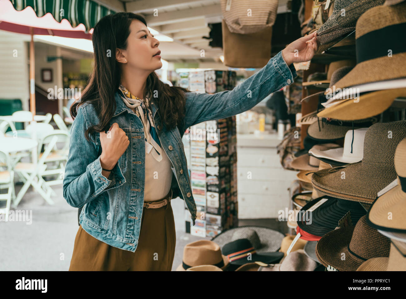 Woman picking hat hat au vendeur, elle est le choix le plus adapté à son chapeau Banque D'Images