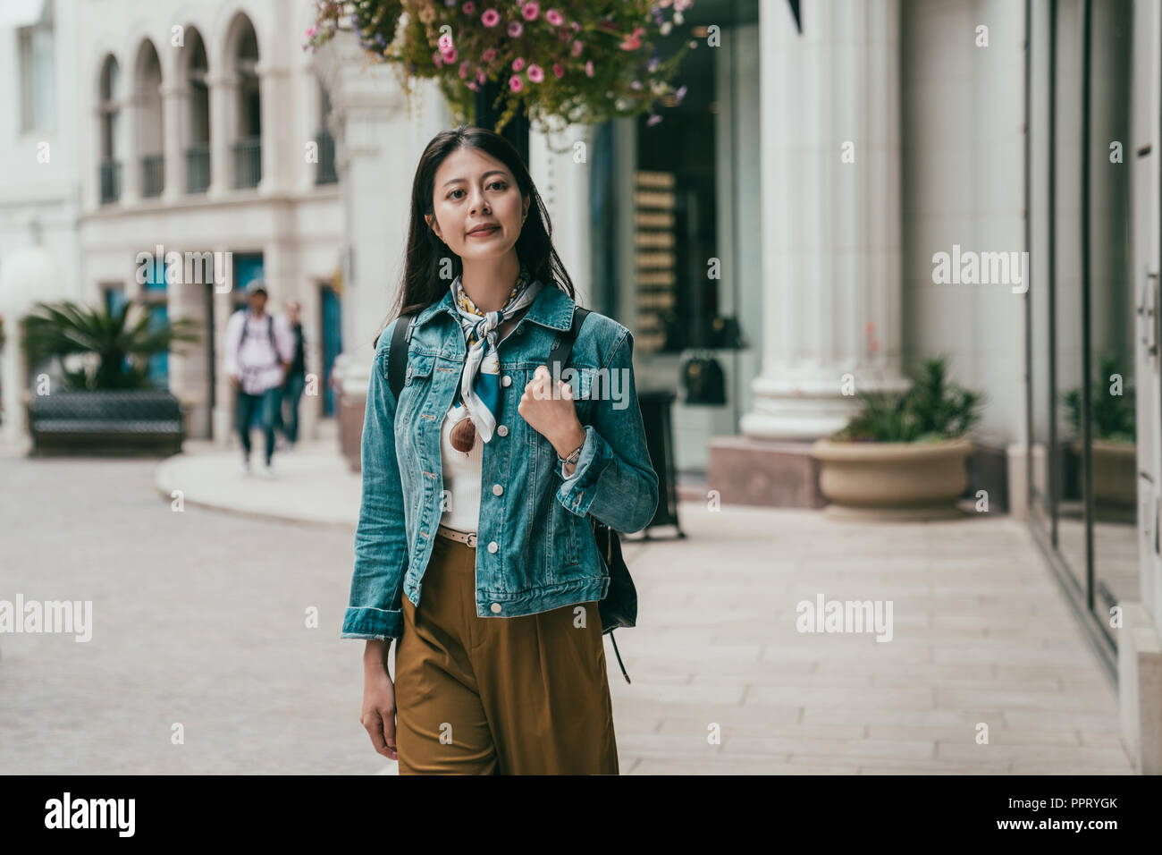 Young female traveler smiling marche dans la rue avec des yeux plein de curieux sentiment Banque D'Images