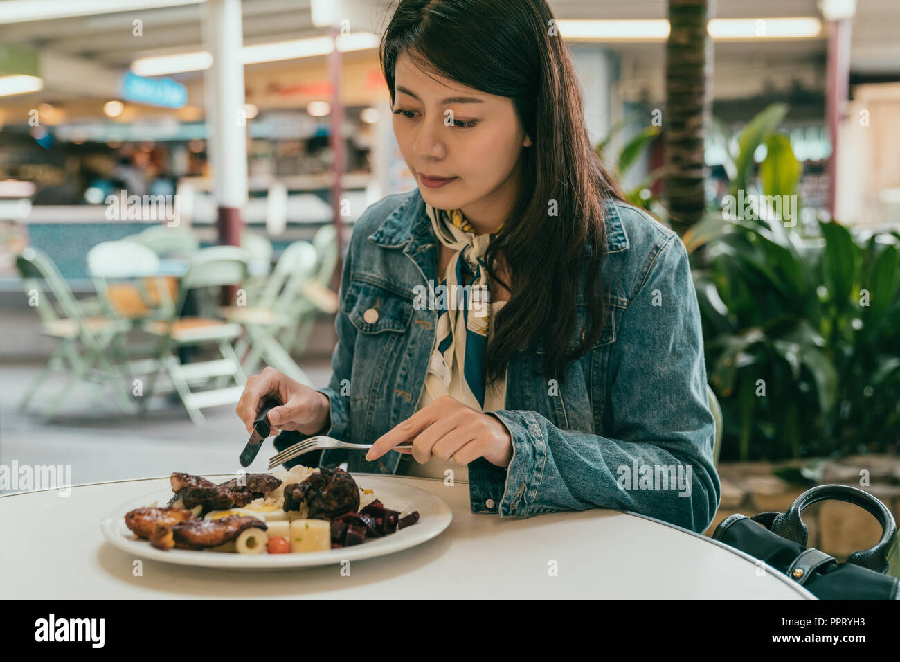 Femme élégante à l'extérieur de l'alimentation, elle est maintenant le couteau et fourchette pour manger sa lave Banque D'Images