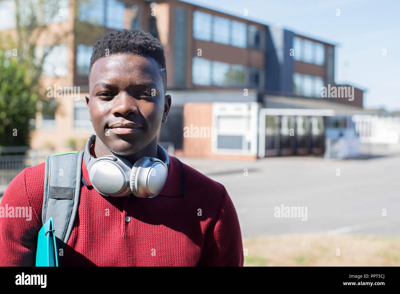 Portrait Of Male Teenage Student à l'extérieur du bâtiment du Collège portant un casque sans fil Banque D'Images