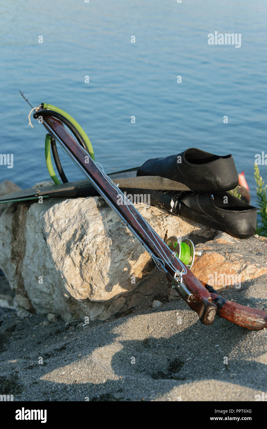 De la pêche au harpon - palmes, au fusil-harpon sur un rocher sur la mer  bleu de la mer, de l'espace pour le texte d'arrière-plan Photo Stock - Alamy