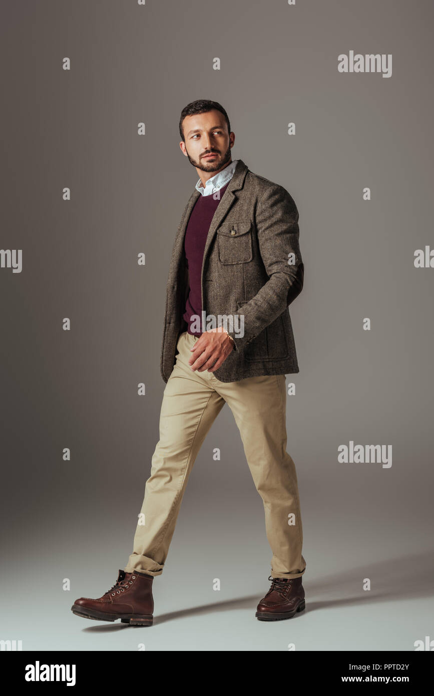 L'homme élégant qui posent en beige pantalon et veste en tweed d'automne,  sur gris Photo Stock - Alamy