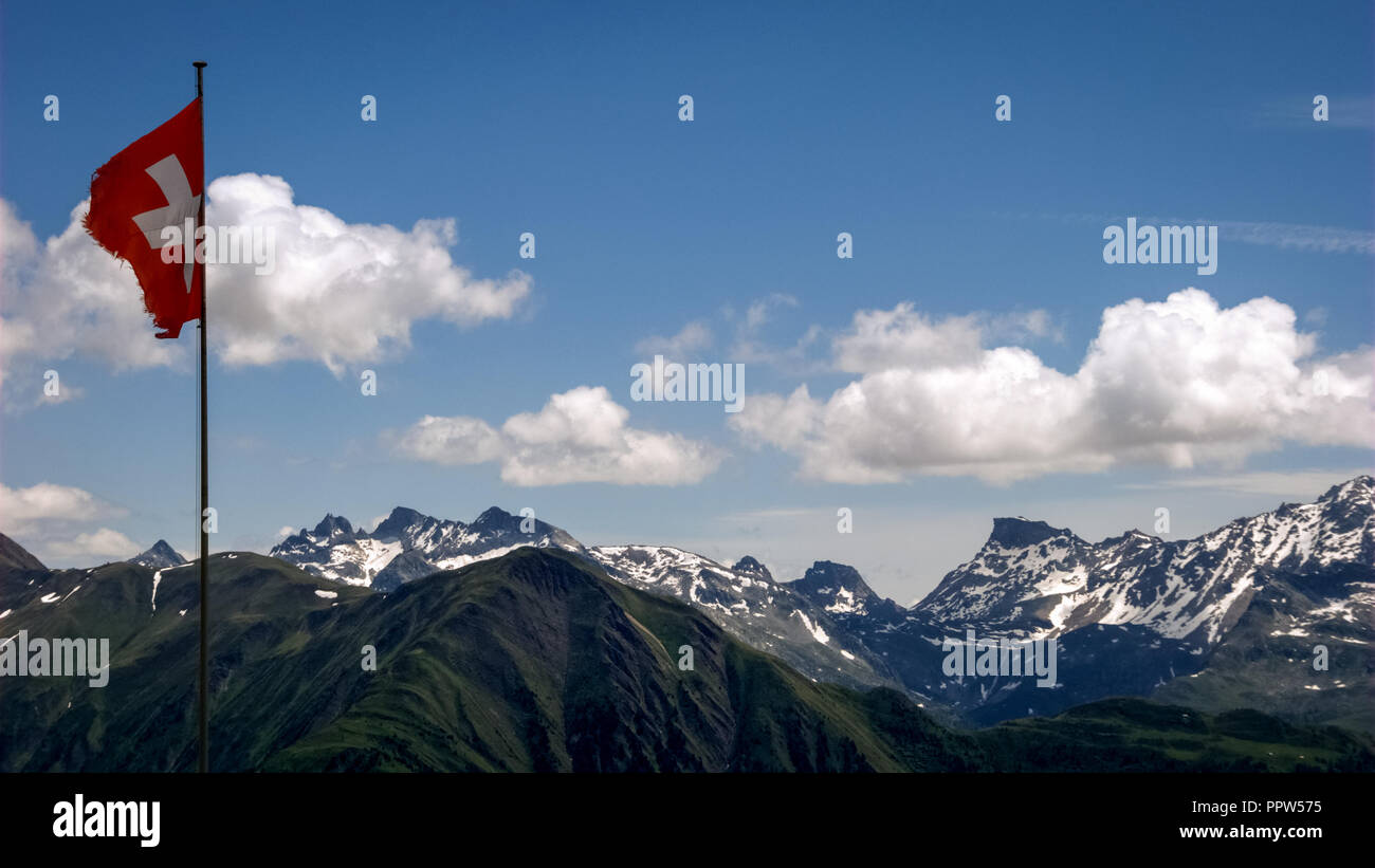 Près du village de Bettmeralp dans le canton du Valais en Suisse et du célèbre Glacier d'Aletsch, le vent joue avec un drapeau suisse Banque D'Images