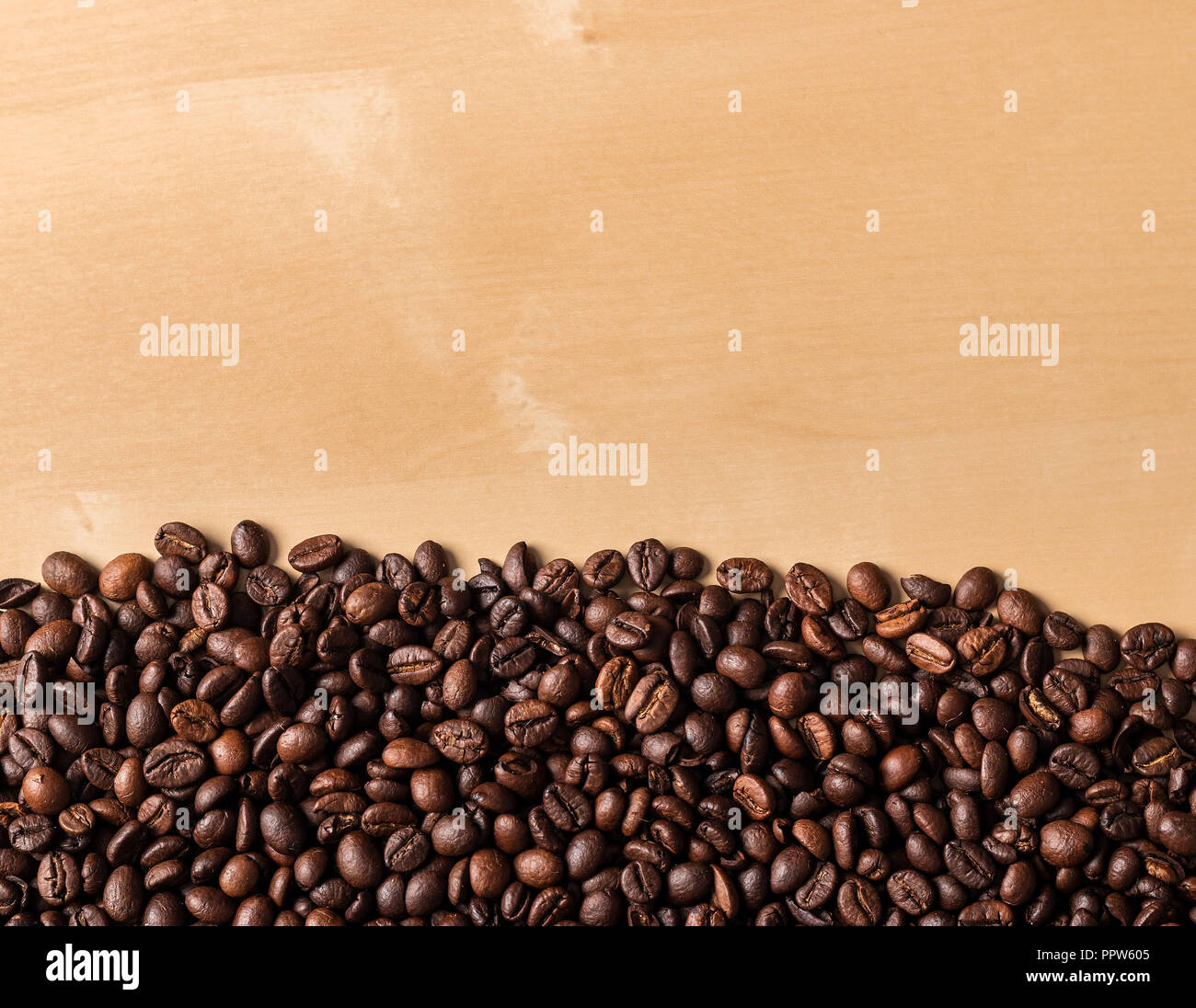 Vue de dessus de grains à café renversé sur la table en bois beige Banque D'Images