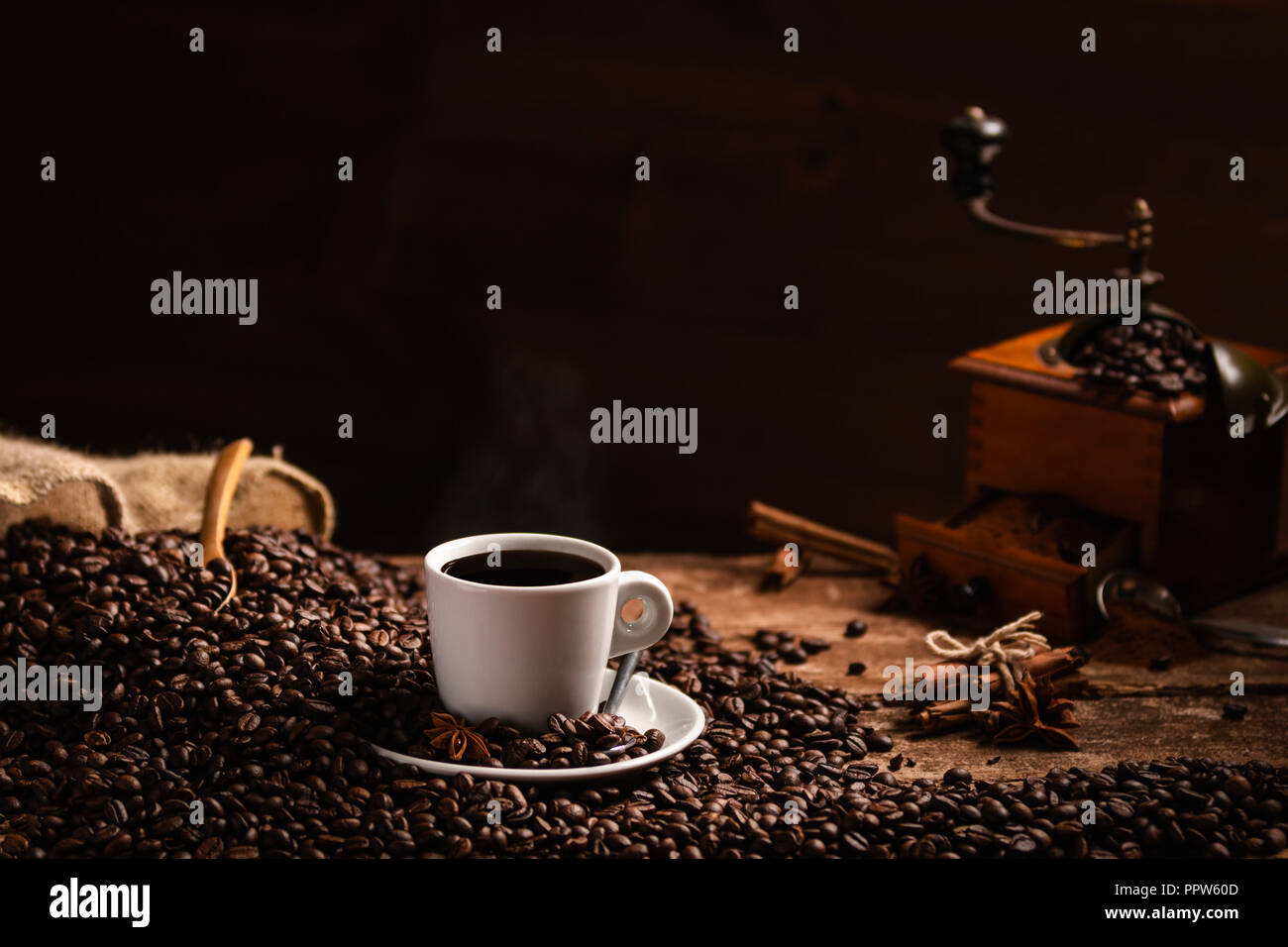 Blanc, les grains de café tasse de café parfumé et rectifieuse de café sur la table en bois sur fond noir Banque D'Images