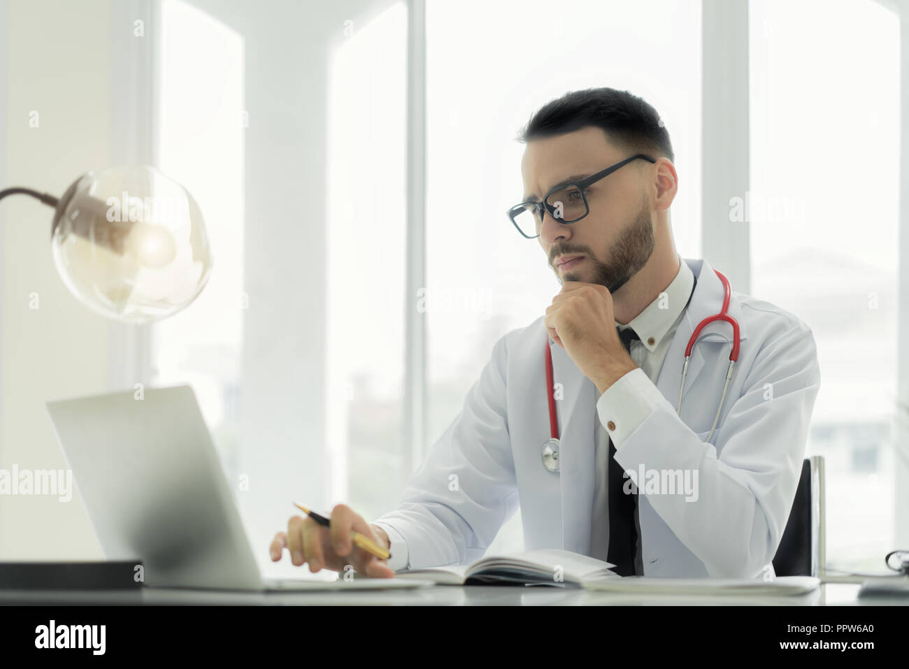 Médecin à l'aide d'ordinateur portable et de dossiers médicaux électroniques. De données numériques sur les soins de santé du patient et des renseignements personnels sur l'écran d'ordinateur. Banque D'Images