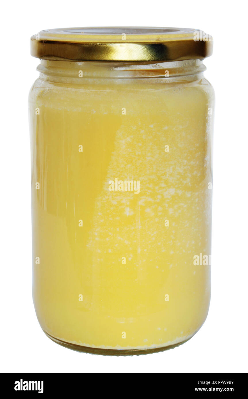 Ma mère âgée verse le miel rural réel pour le petit-déjeuner dans un bocal en verre et se ferme avec un couvercle hermétique. Isolé sur blanc avec patch Banque D'Images