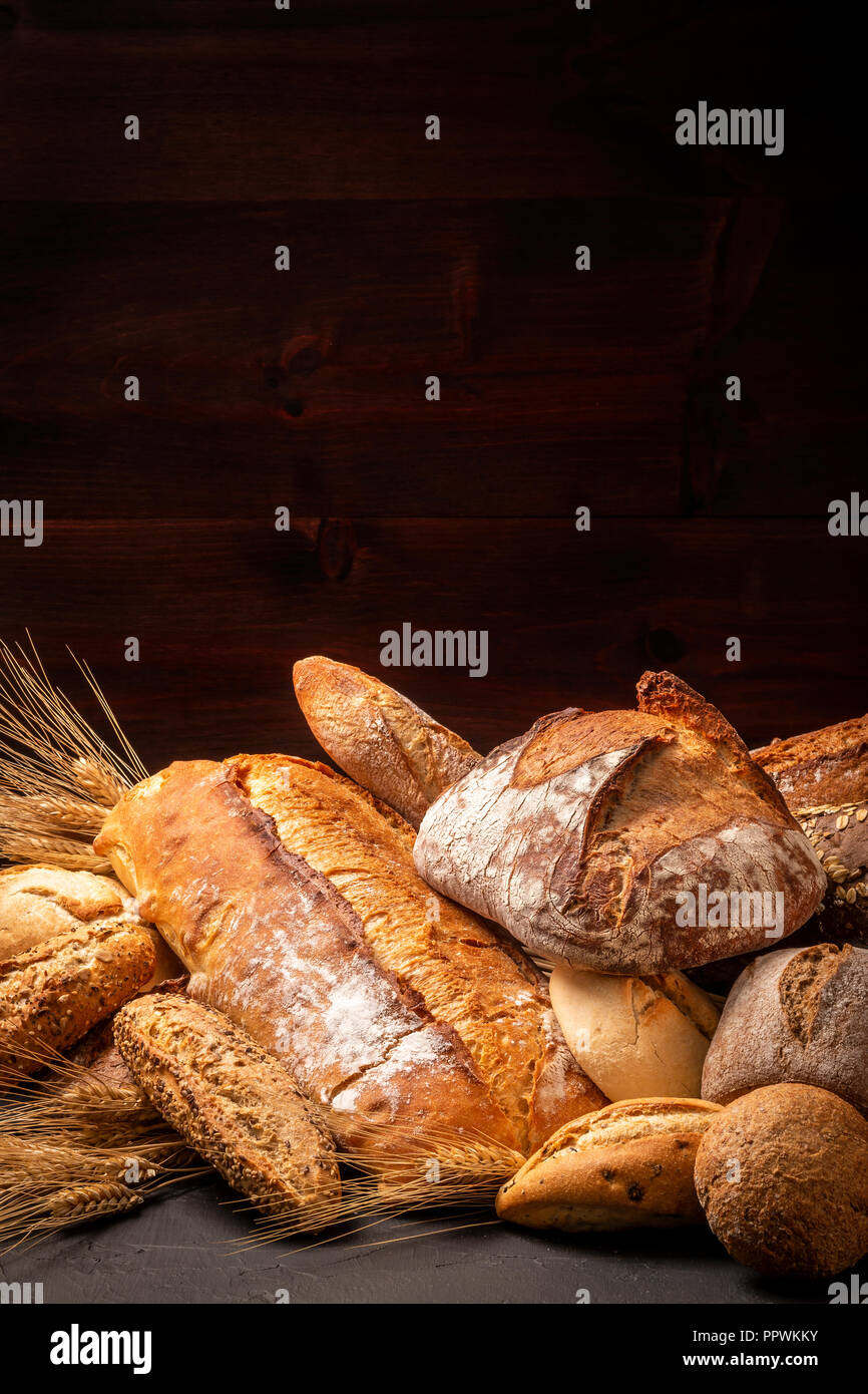 Composition de l'abondance des miches de pain fraîchement cuit et des brioches avec des épis de blé Banque D'Images