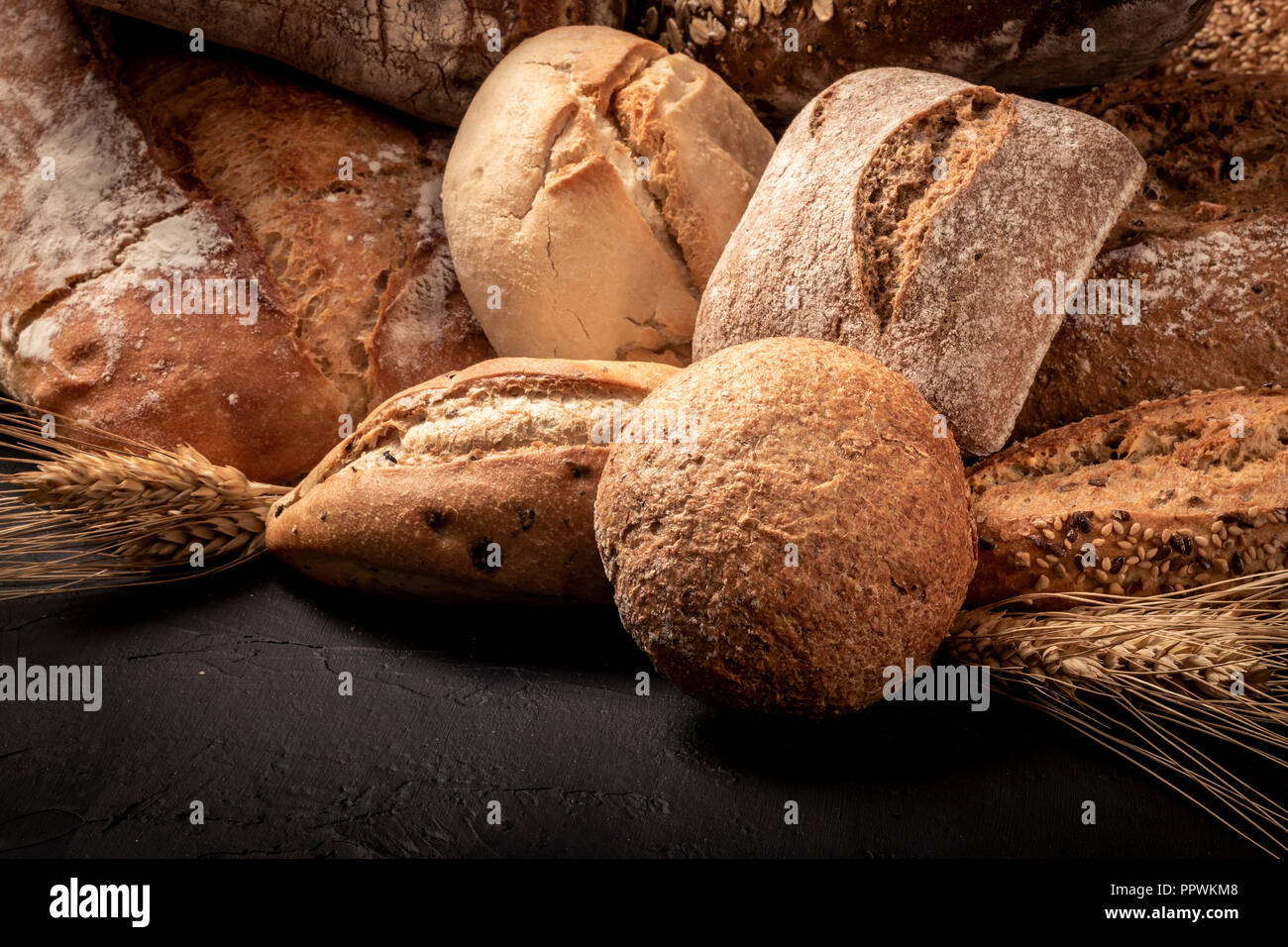 Composition de l'abondance des miches de pain fraîchement cuit et des brioches avec des épis de blé Banque D'Images
