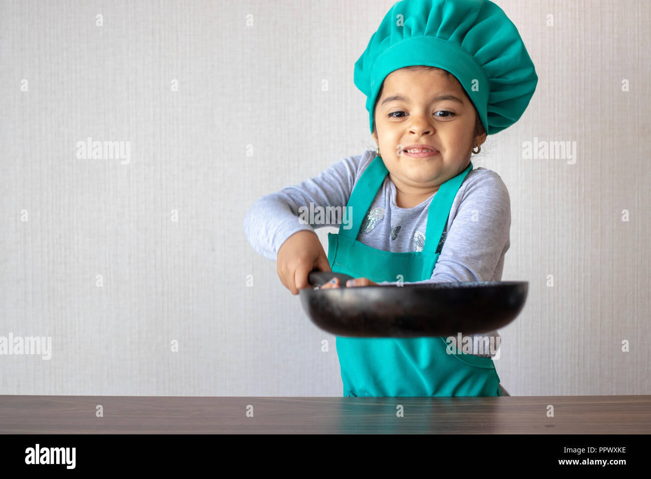 Cute little girl avec son poêle de cuisson dans la cuisine Banque D'Images