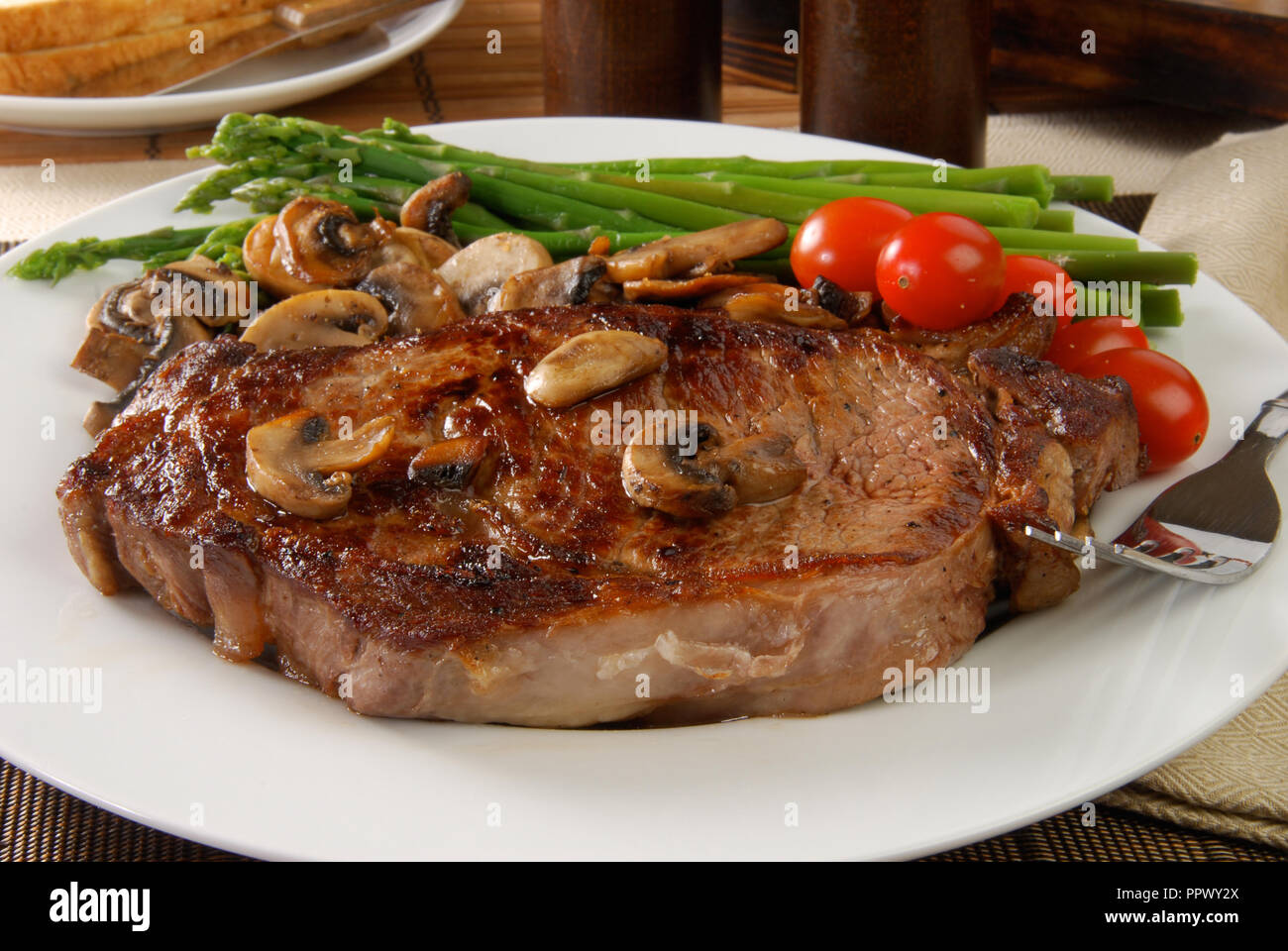 Une côte de boeuf grillée avec champignons sautés Banque D'Images