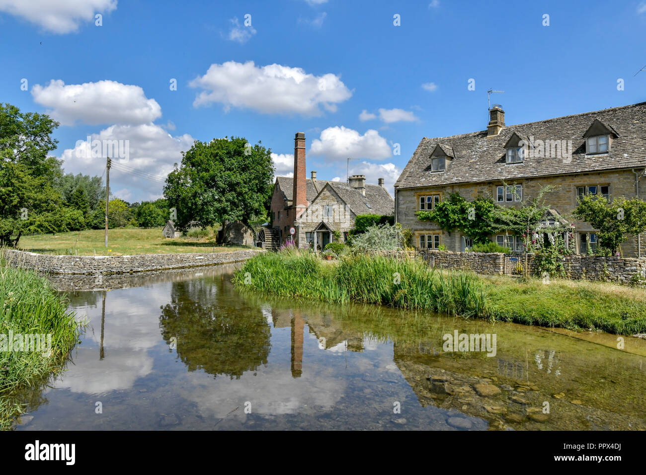 L'Angleterre, Gloucestershire, Cotswolds, Lower Slaughter en été, riverside cottages en pierre de Cotswold Banque D'Images