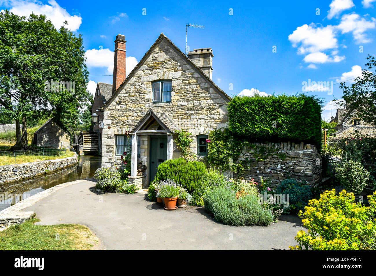 L'Angleterre, Gloucestershire, Cotswolds, Lower Slaughter en été, riverside cottages en pierre de Cotswold Banque D'Images