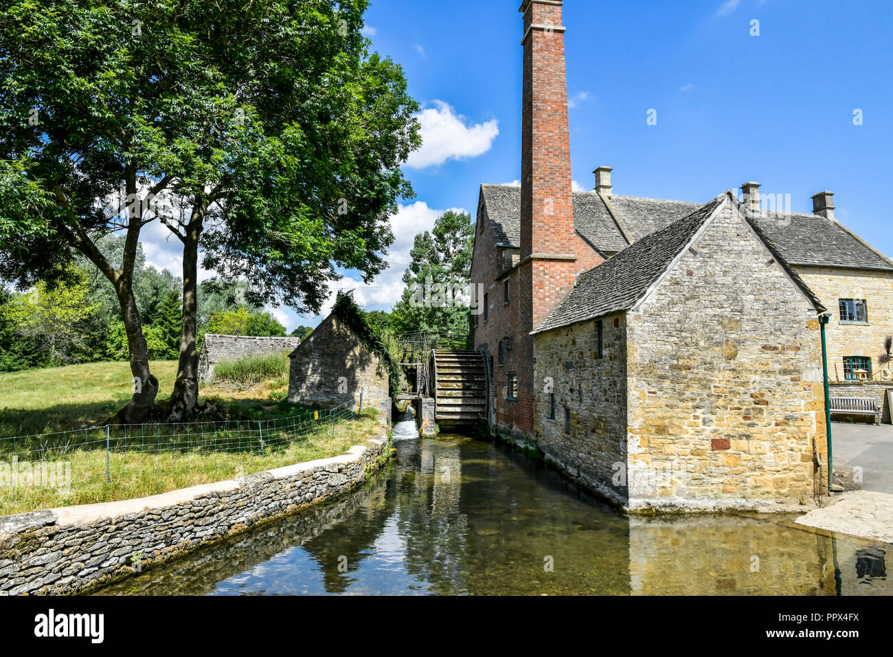 L'Angleterre, Gloucestershire, Cotswolds, Lower Slaughter en été, riverside cottages en pierre de Cotswold Banque D'Images