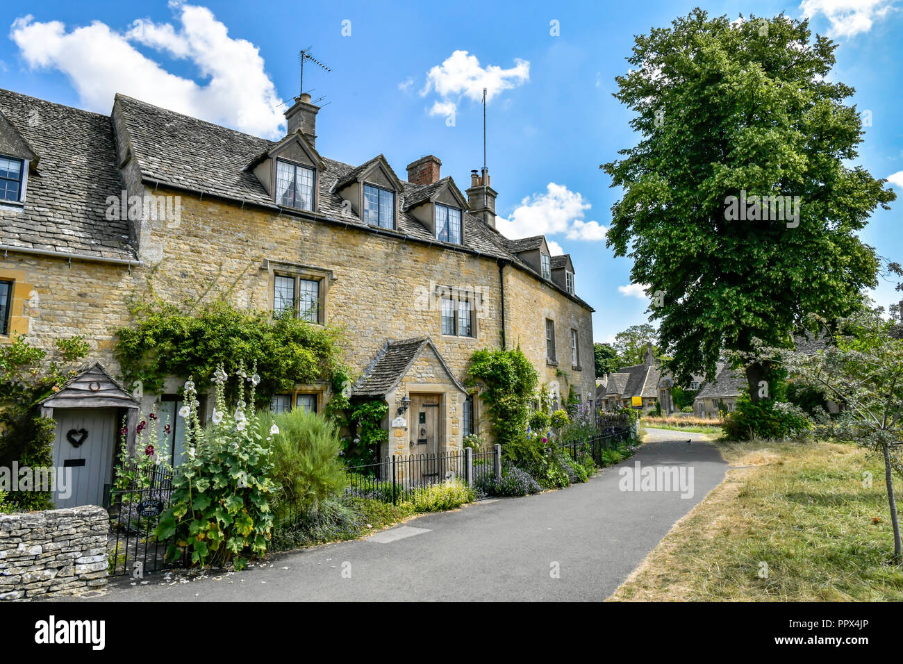 L'Angleterre, Gloucestershire, Cotswolds, Lower Slaughter en été, riverside cottages en pierre de Cotswold Banque D'Images