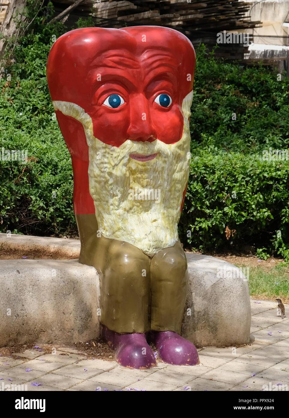 Une figure illustrant le cœur sous la forme d'un vieil homme avec une barbe blanche faite d'un rouge vif. La figure est dans le parc de la ville Holon Banque D'Images