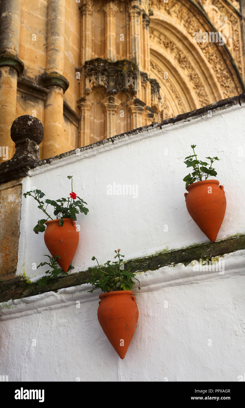 Pots en terre cuite et murs blancs lavés avec des arcs au-dessus d'une ruelle dans le centre historique d'Arcos de la Frontera, Andalousie, espagne. Banque D'Images