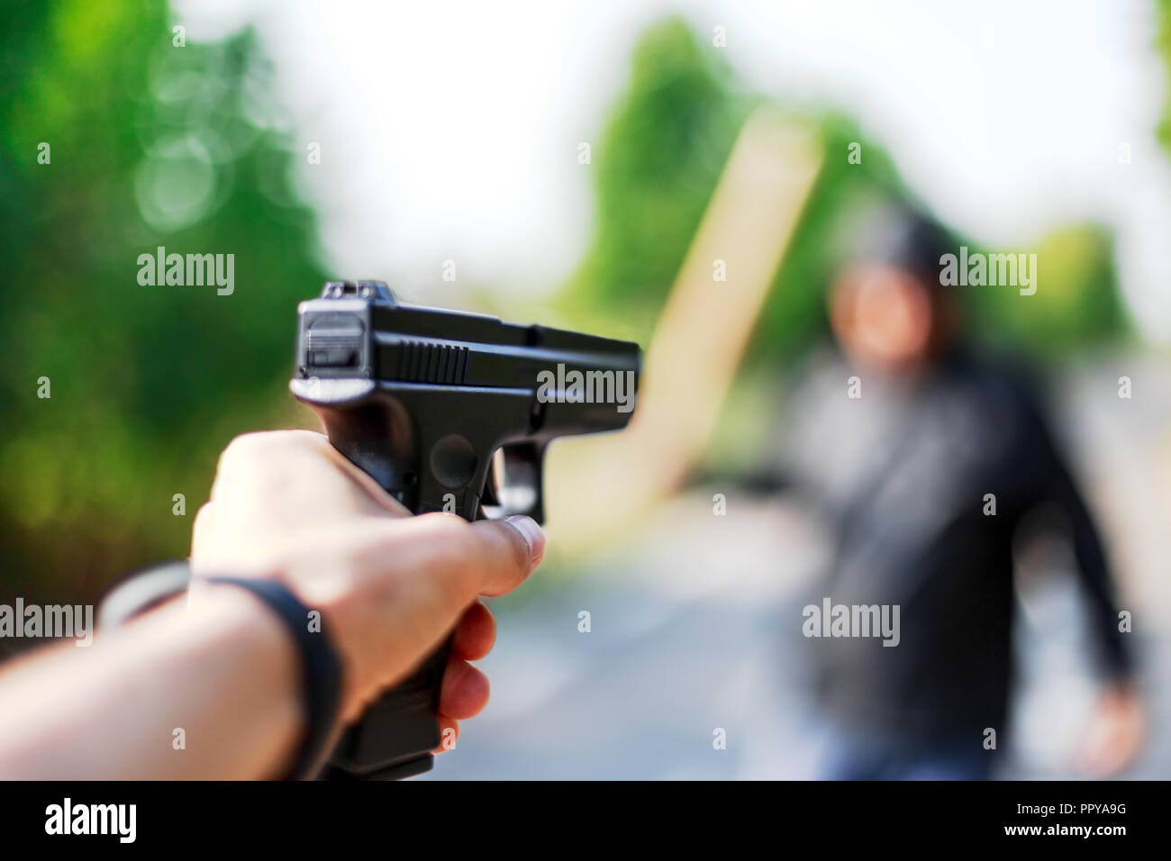 Personne pointant une arme sur l'attaquant. Concept de défense automatique. Banque D'Images