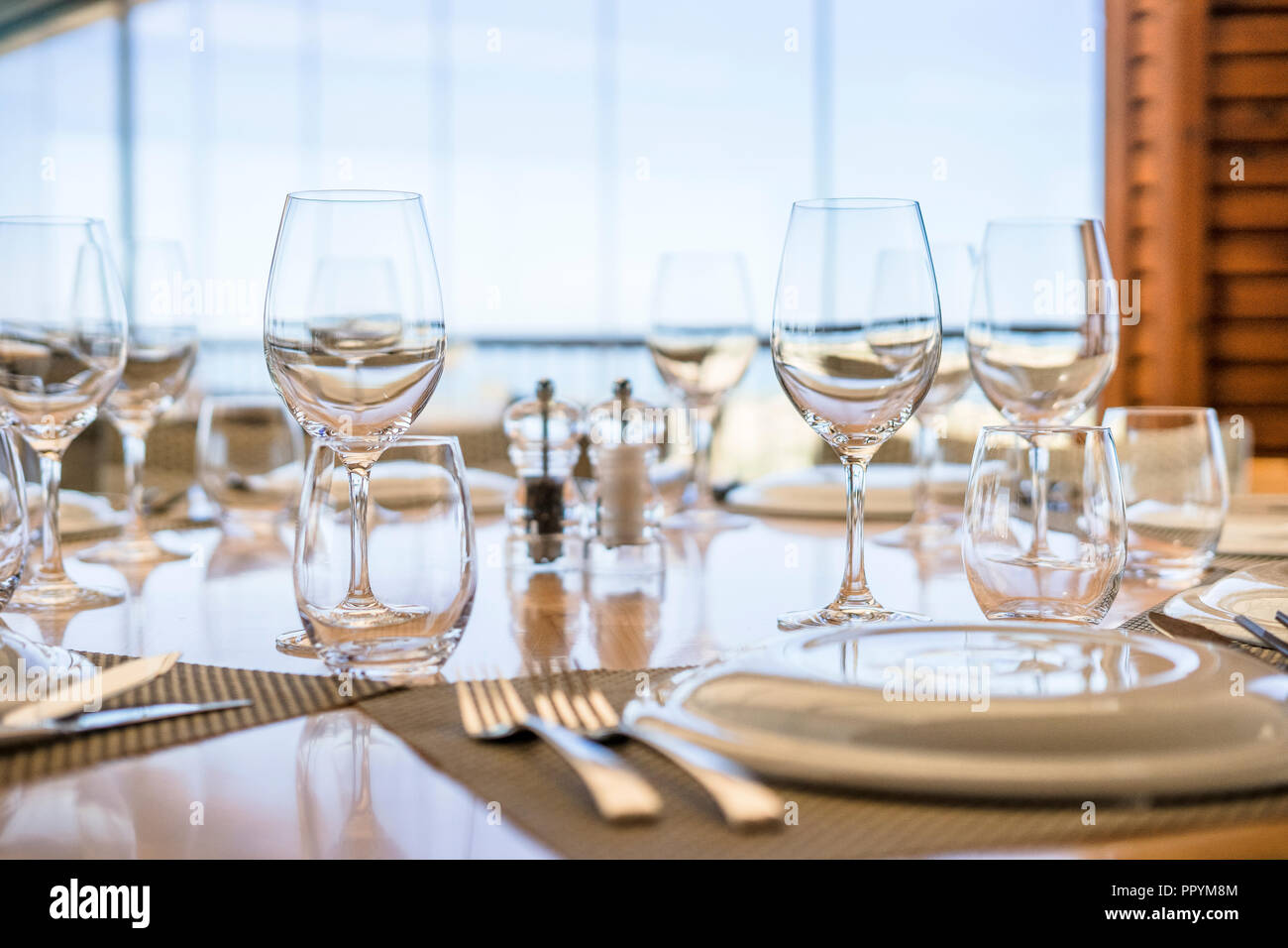 Table avec assiettes, verres et couverts prêt pour le déjeuner dans un restaurant élégant Banque D'Images