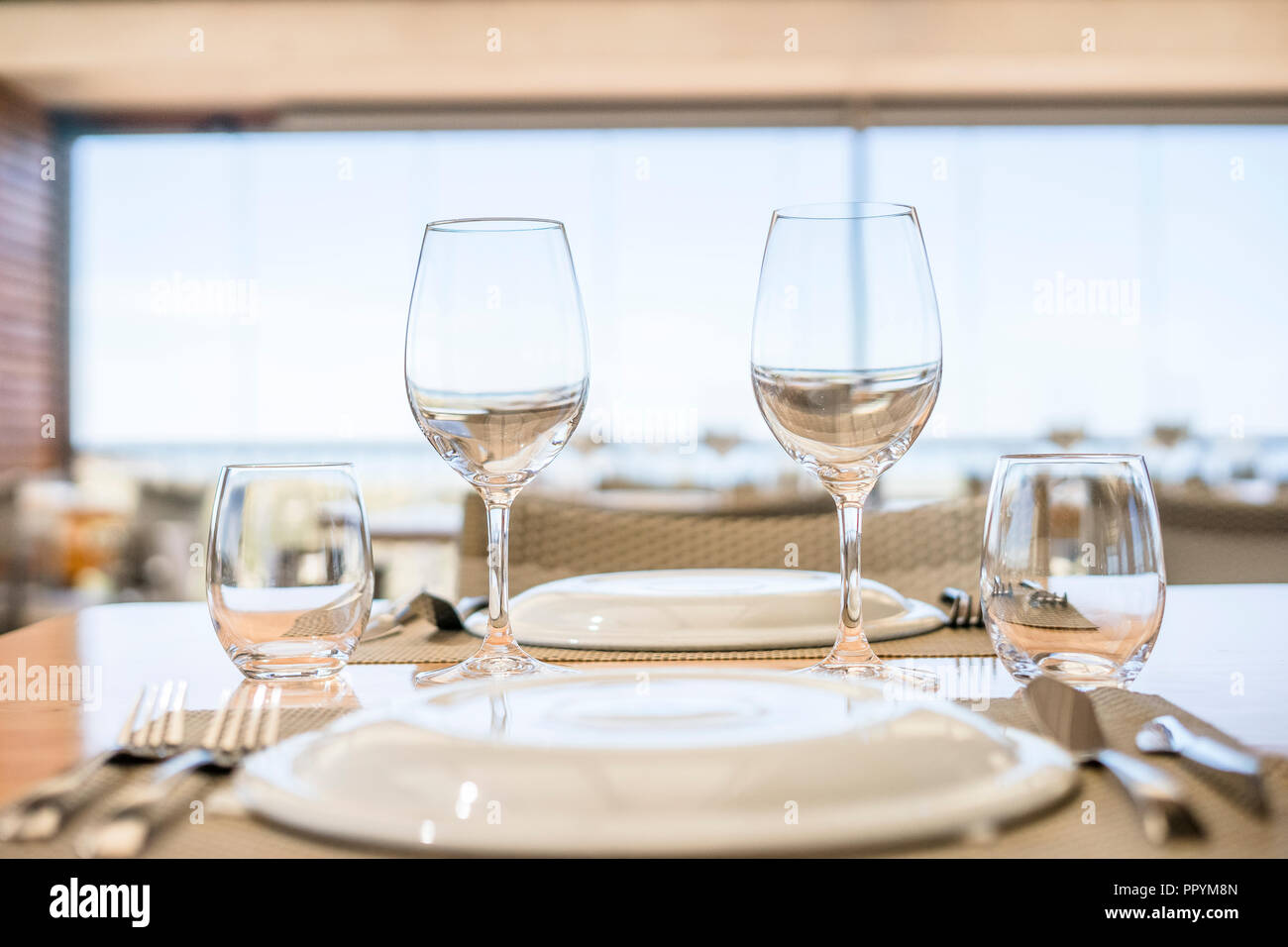 Table avec assiettes, verres et couverts prêt pour le déjeuner dans un  restaurant élégant Photo Stock - Alamy