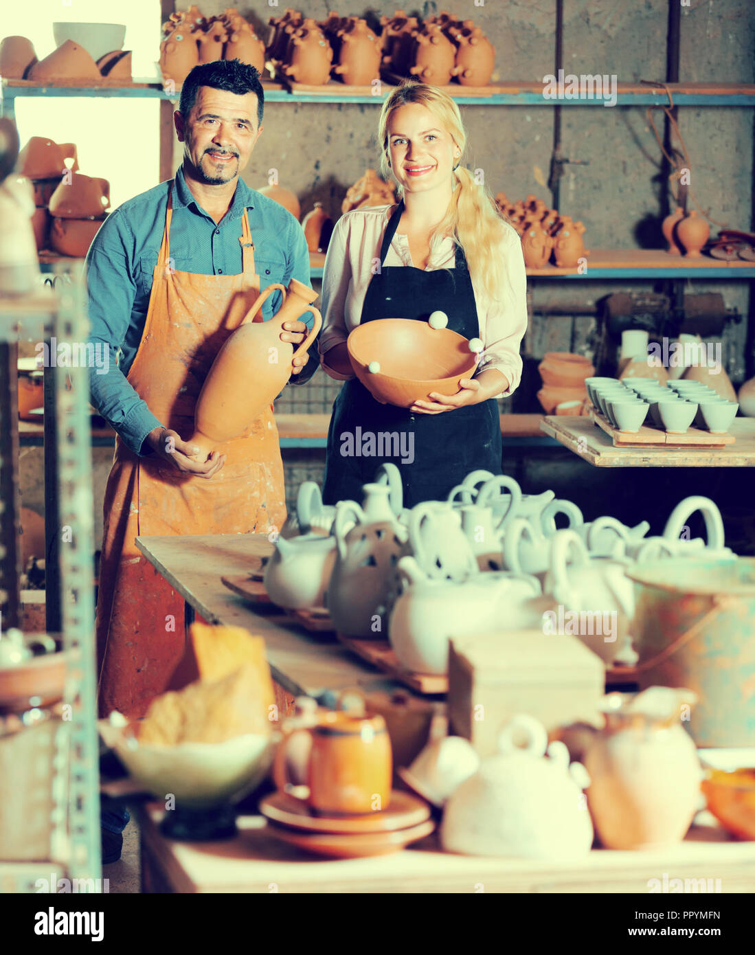 Deux artisans en tenant les mains et en céramique à l'atelier permanent Banque D'Images