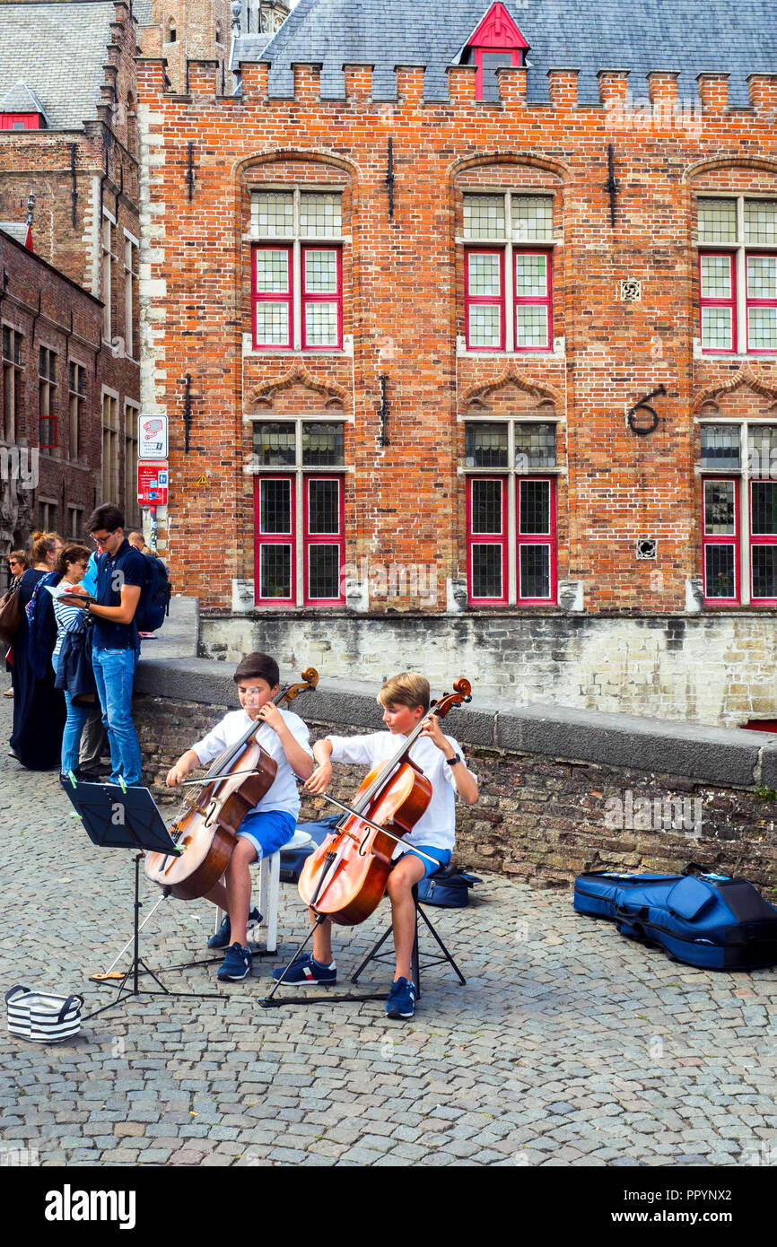 Deux jeunes musiciens qui jouent du violoncelle dans le centre historique - Bruges, Belgique Banque D'Images