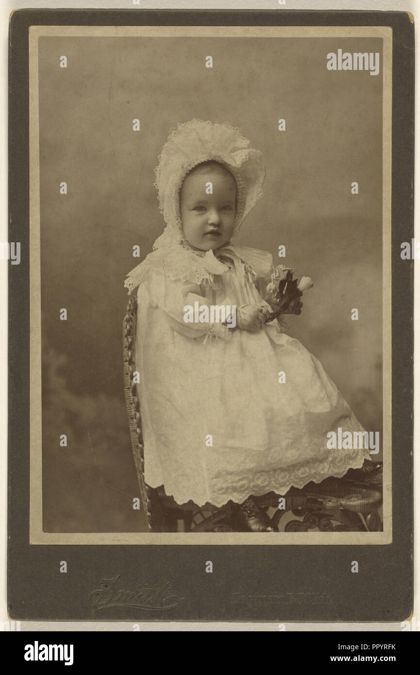 Bébé portant un bonnet, tenant une fleur, assis ; Smith, États-Unis, actif  à Burlington, Iowa 1870, 1894 ; Albumen silver Photo Stock - Alamy