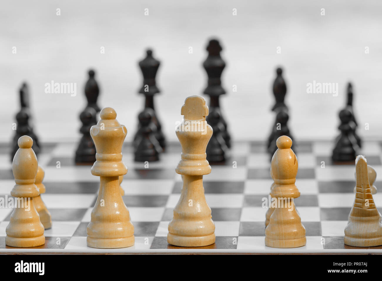 Pièces des échecs en bois Close up à bord sur fond lumineux. Selective focus sur les pièces blanches. Jeu d'échecs en plein air Banque D'Images