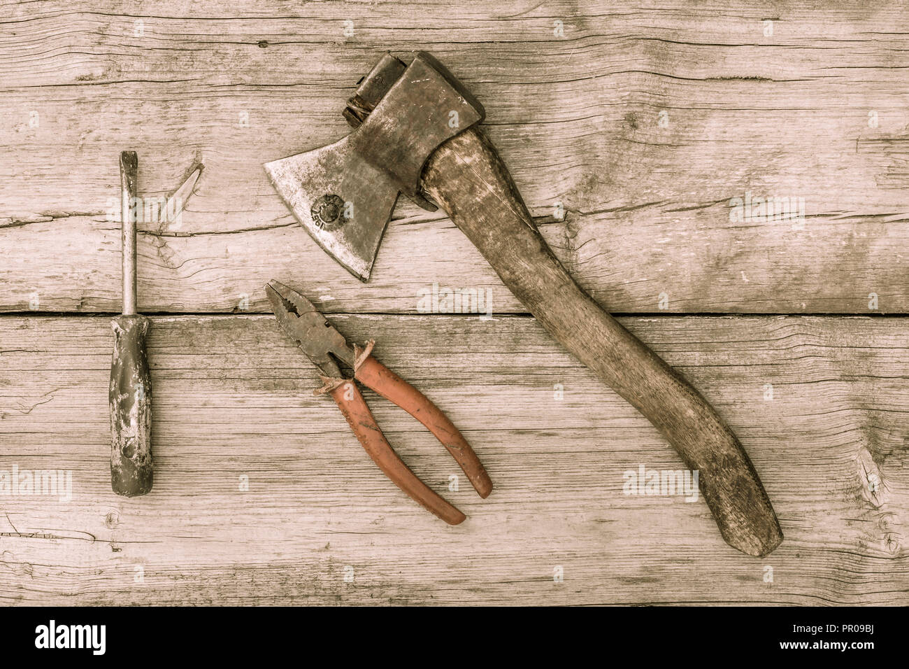 Outils anciens sur fond de bois. Vitraux anciens ax, pinces et tournevis sur vieille surface en bois. Style Vintage Banque D'Images