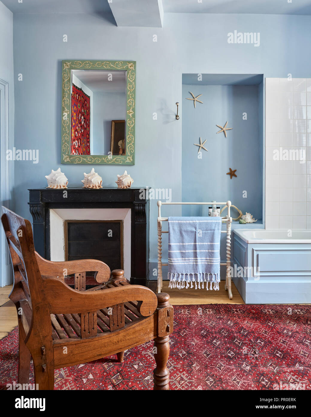 Chaise en bois sculpté à la lumière salle de bains bleue avec les coquillages Banque D'Images