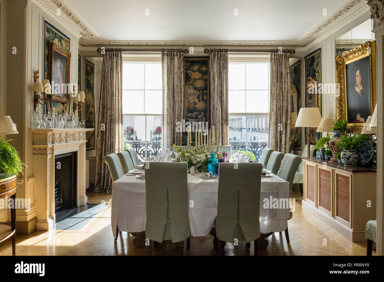 Table à manger carrée avec de grandes fenêtres à guillotine et des chaises couvertes de verdure du 19e siècle, des panneaux de tapisserie Banque D'Images
