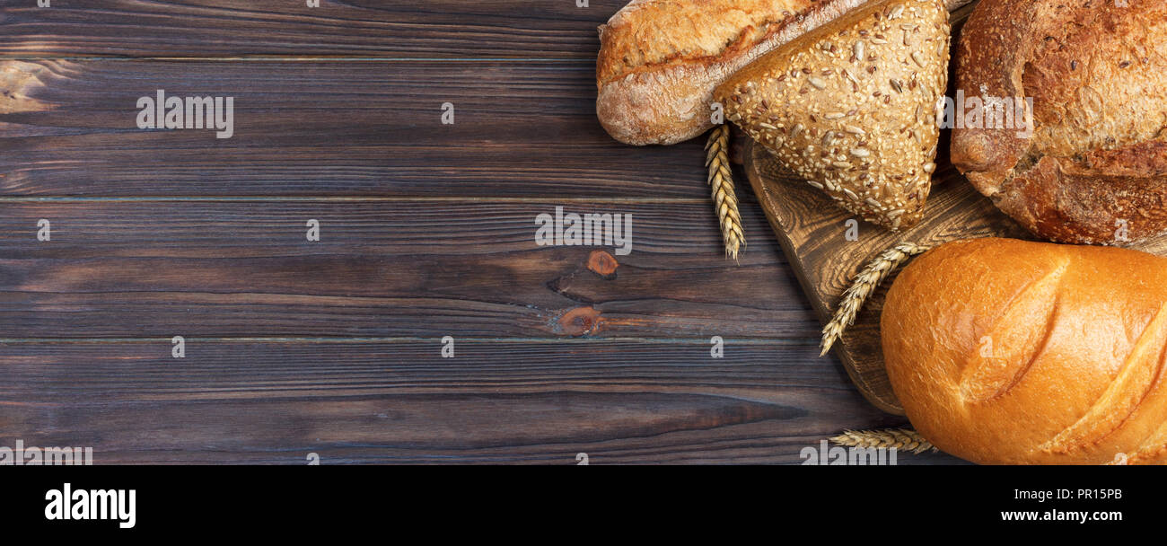 Pain maison cuit au four à pain de blé sur fond de bois. banner pour la publicité et le design, promo Vue supérieure avec copie espace. Banque D'Images