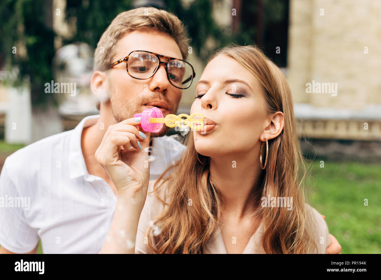 Beau jeune couple soufflant des bulles de savon ensemble Banque D'Images