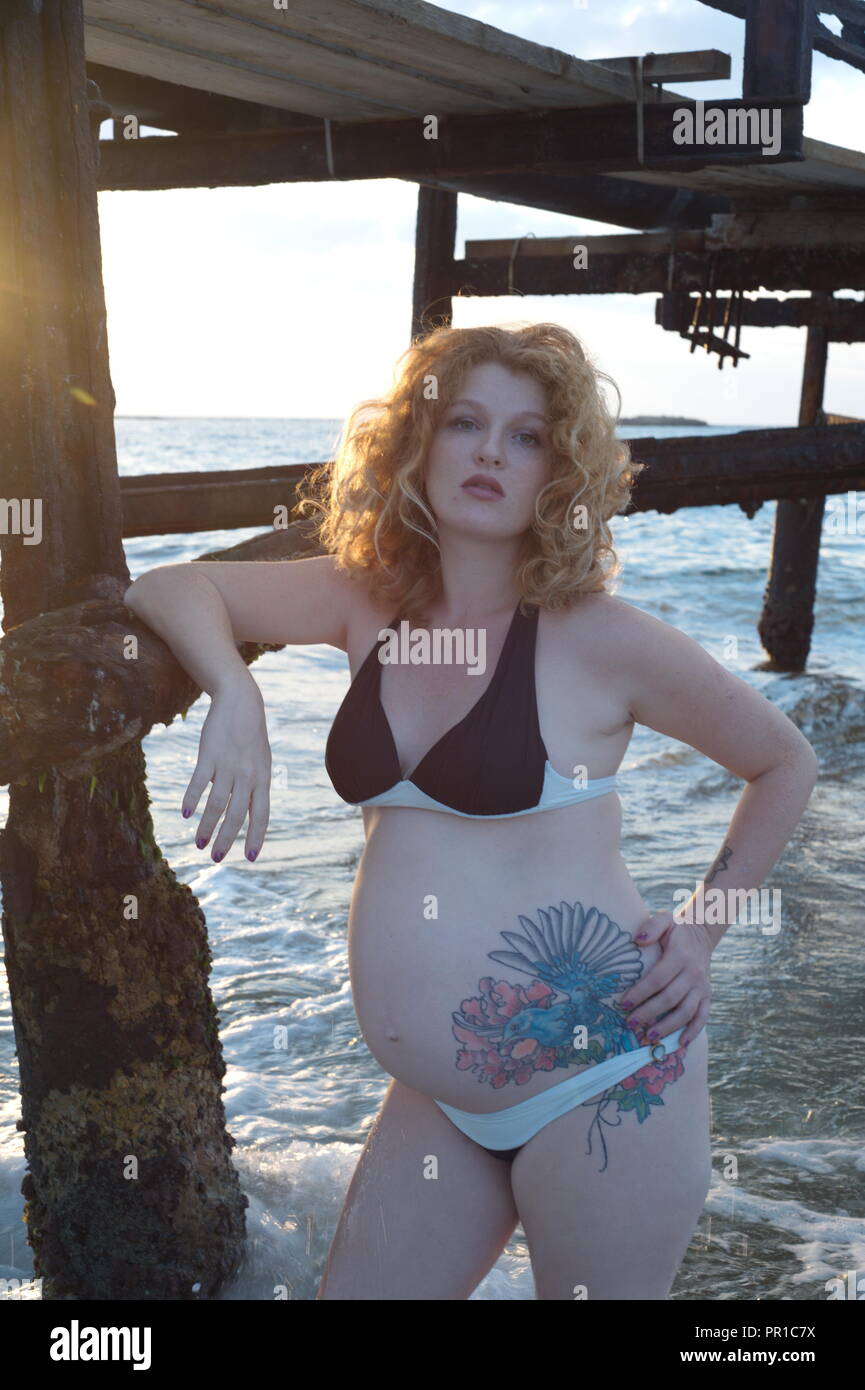 La grossesse femme avec le tatouage, dans la mer de la côte Banque D'Images