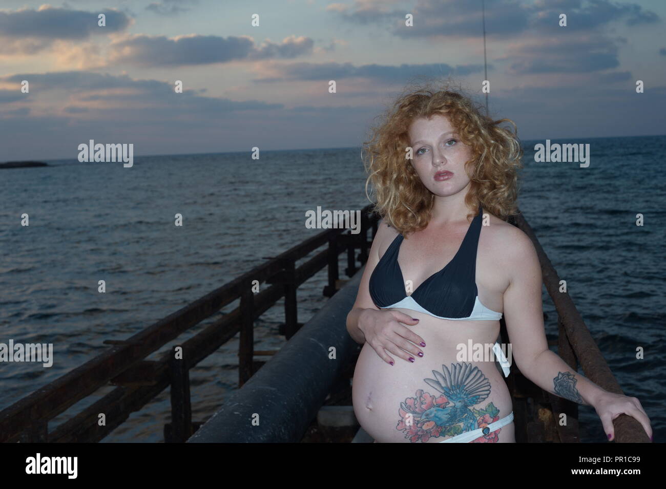 Femme grossesse incroyable avec le tatouage, dans la mer de la côte Banque D'Images