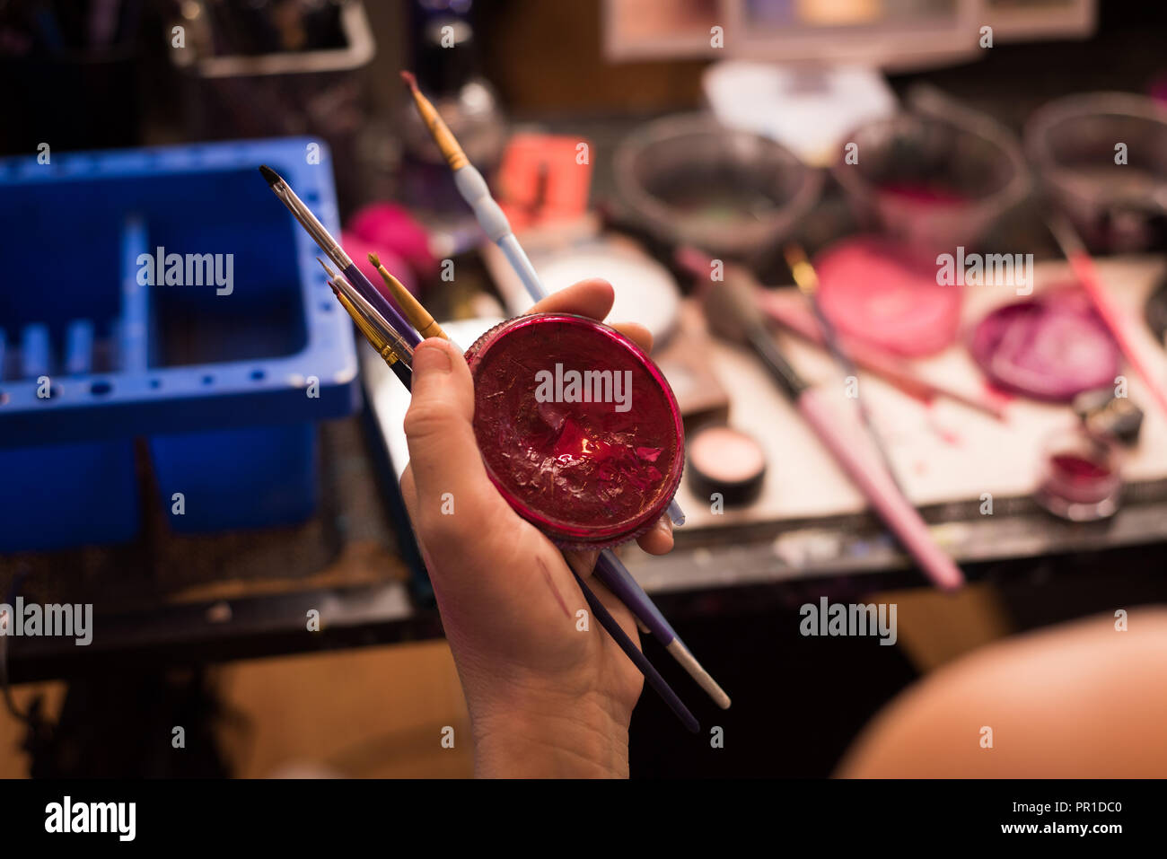 Woman holding red contenant de peinture et pinceaux Banque D'Images