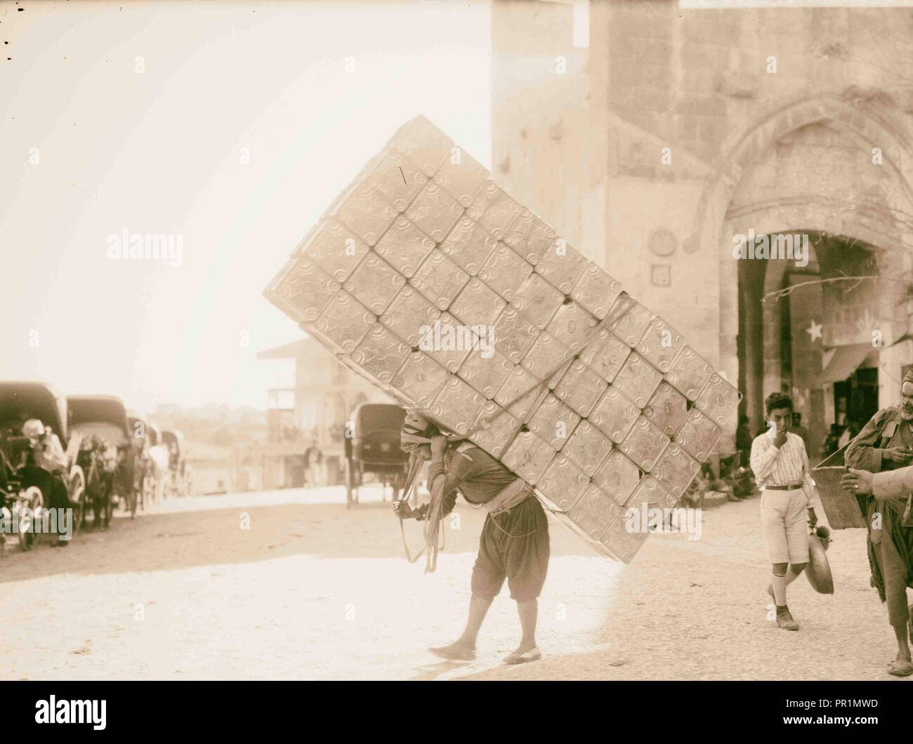 Types de la ville. Jérusalem porter. (D'énorme charge d'essence vide tins) 1898, Jérusalem, Israël Banque D'Images