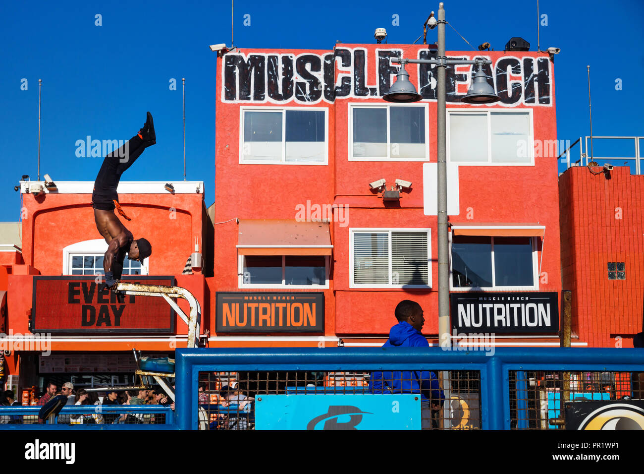Venice Beach, Los Angeles, Californie - Le 25 février 2018 : formation de l'homme devant les yeux et le bâtiment orange muscle beach Banque D'Images