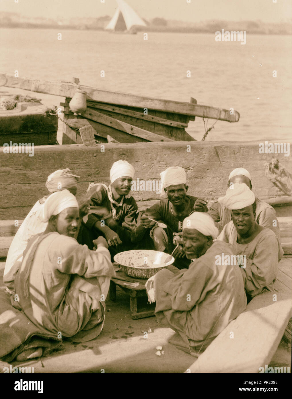 Le Caire, Égypte et du district. Déjeuner sur le Nil. Bateliers à leur repas de midi. 1934, l'Égypte, Le Caire Banque D'Images